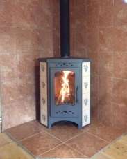 Недорогая печь-камин Бавария угловая с плитой незабудка Амазонка бай фото в интерьере в Пинске