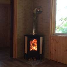 Стальной камин с большим стеклом Бавария угловая Амазонка бай фото в интерьере в Пинске